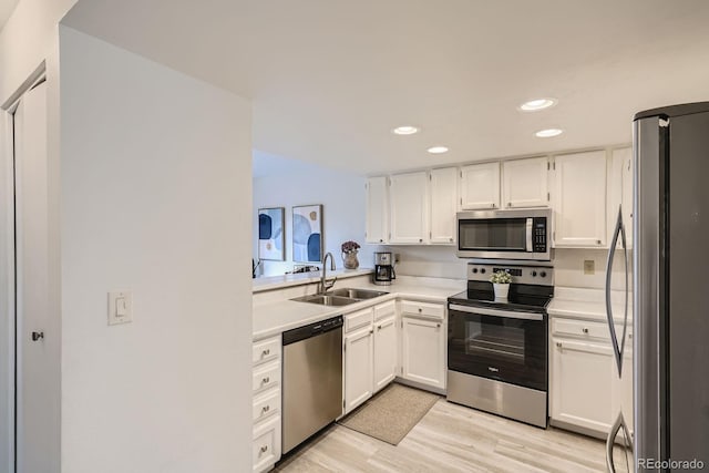 108 S Holman Way, Golden, CO 80401 - kitchen with stainless steel appliances, white cabinets, light countertops, light wood finished floors, and recessed lighting