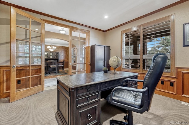 office space featuring a wainscoted wall, an inviting chandelier, crown molding, and light colored carpet