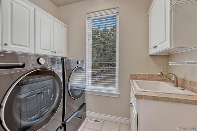 laundry area featuring washer and clothes dryer, a sink, baseboards, visible vents, and cabinet space