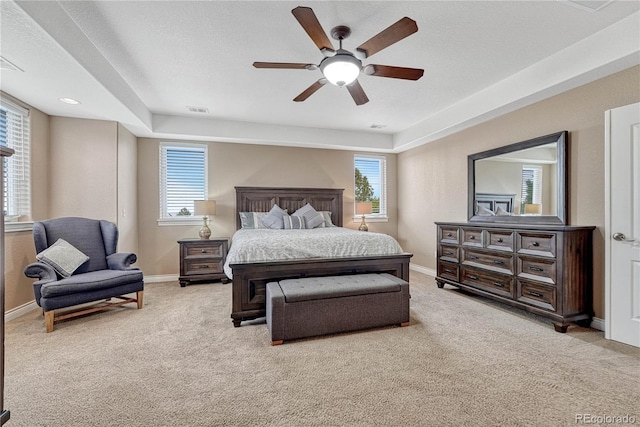bedroom with baseboards, visible vents, multiple windows, and light carpet