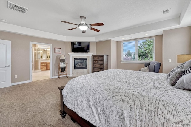 bedroom with baseboards, visible vents, carpet flooring, and a glass covered fireplace
