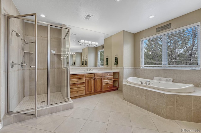 bathroom featuring tile patterned flooring, vanity, a shower stall, visible vents, and a bath