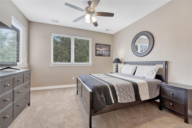 bedroom featuring baseboards, visible vents, multiple windows, and light carpet