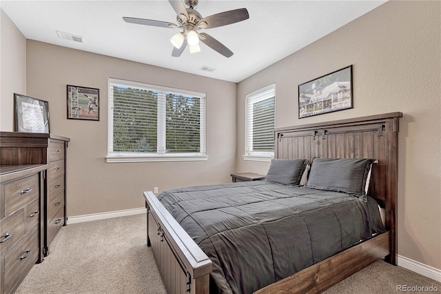 bedroom with a ceiling fan, light carpet, baseboards, and visible vents