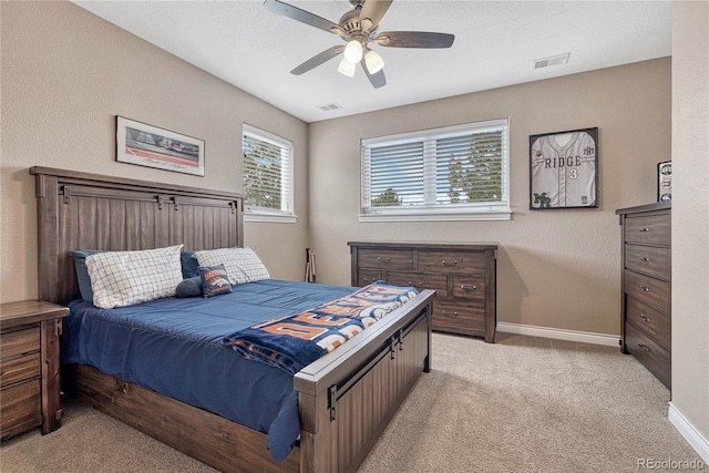 bedroom featuring light carpet, baseboards, visible vents, and a ceiling fan
