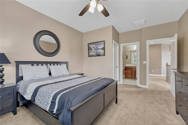 bedroom with ensuite bathroom, baseboards, light colored carpet, visible vents, and ceiling fan