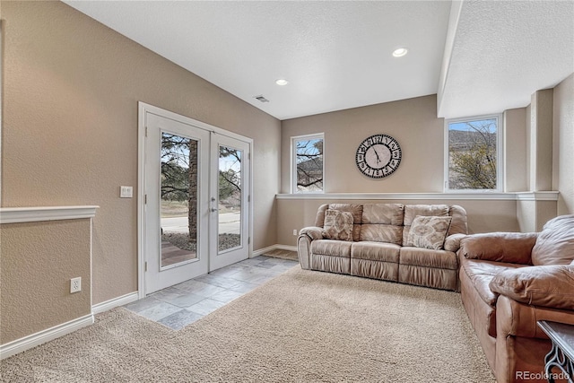 living area with french doors, a textured wall, and visible vents