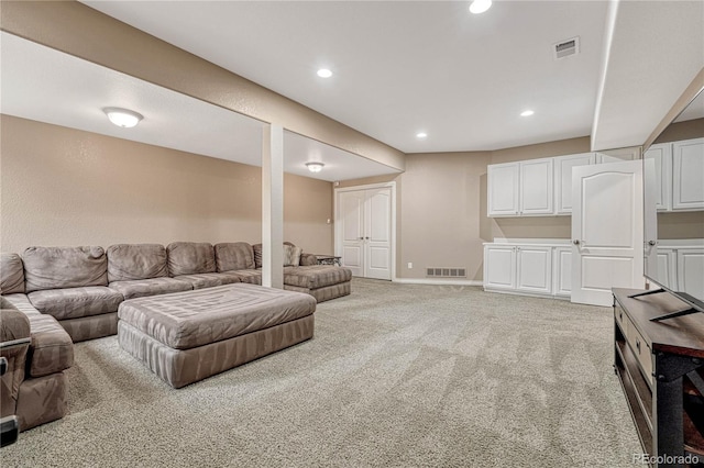 living area featuring visible vents, recessed lighting, and light colored carpet