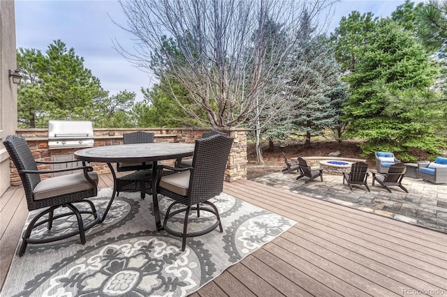 wooden deck featuring a fire pit, outdoor dining area, and grilling area