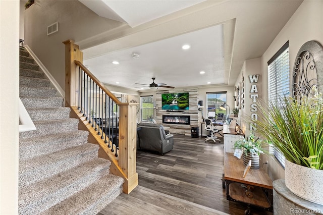 3871 Starry Night Loop, Castle Rock, CO 80109 - living room featuring a glass covered fireplace, stairs, wood finished floors, ceiling fan, and healthy amount of natural light
