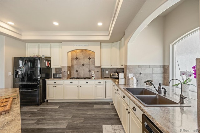 3871 Starry Night Loop, Castle Rock, CO 80109 - kitchen with black refrigerator with ice dispenser, a tray ceiling, dark wood-type flooring, light stone counters, and recessed lighting