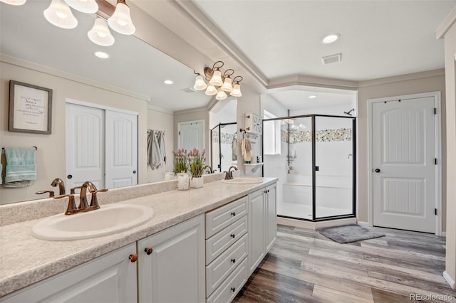 3871 Starry Night Loop, Castle Rock, CO 80109 - bathroom featuring double vanity, crown molding, a shower stall, wood finished floors, and recessed lighting
