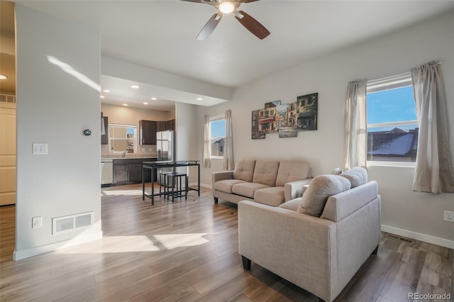 living room featuring ceiling fan and light wood-type flooring