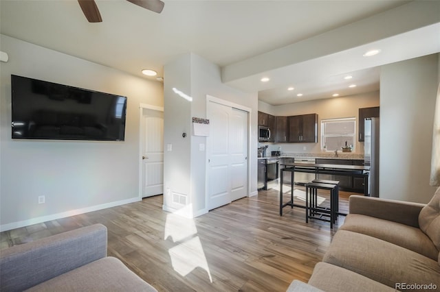 living room featuring ceiling fan and light wood-type flooring