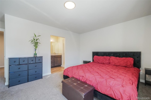 bedroom featuring light colored carpet and ensuite bathroom