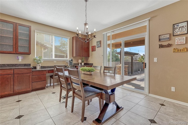 dining area featuring light tile patterned floors, a wealth of natural light, and a textured ceiling