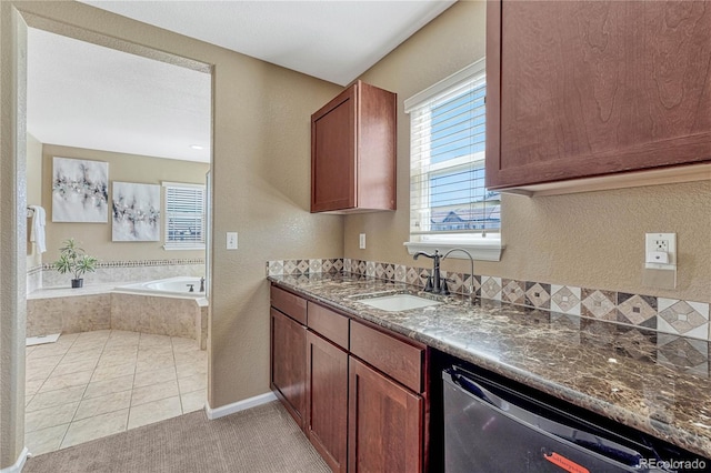 kitchen with dishwashing machine, dark stone counters, a wealth of natural light, and a sink