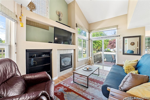 930 Button Rock Dr Unit 28, Longmont, CO 80504 - living area featuring a tile fireplace, wood finished floors, baseboards, and high vaulted ceiling