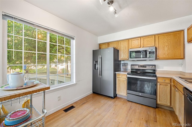 930 Button Rock Dr Unit 28, Longmont, CO 80504 - kitchen with stainless steel appliances, light countertops, light wood-type flooring, track lighting, and baseboards
