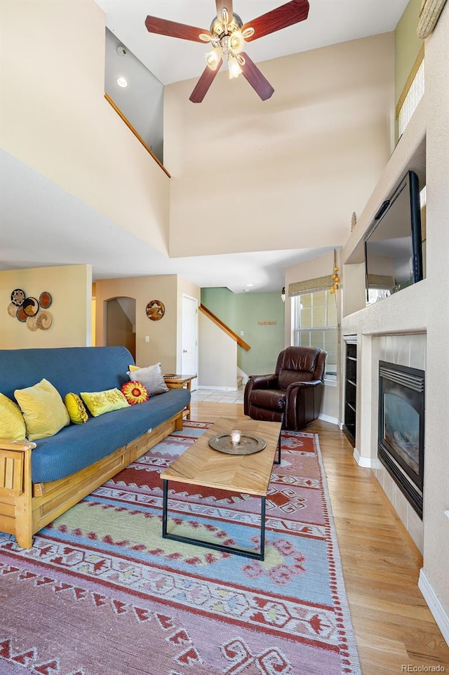 930 Button Rock Dr Unit 28, Longmont, CO 80504 - living area featuring wood finished floors, ceiling fan, baseboards, a tiled fireplace, and stairs