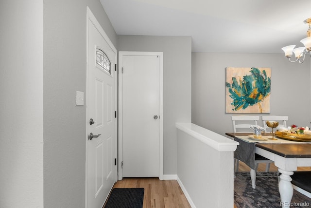 entrance foyer with an inviting chandelier and light hardwood / wood-style floors