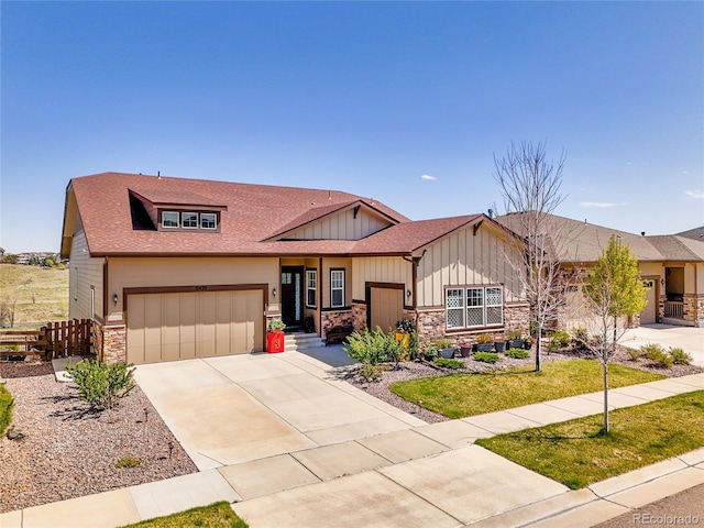 view of front of home featuring stone siding, board and batten siding, driveway, a garage, and a shingled roof