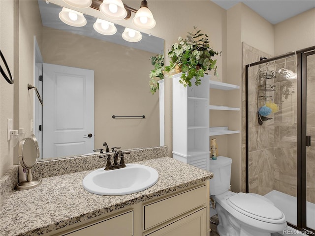 bathroom featuring a shower stall, vanity, and toilet