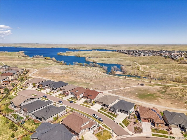 aerial view of property's location featuring a large body of water and nearby suburban area