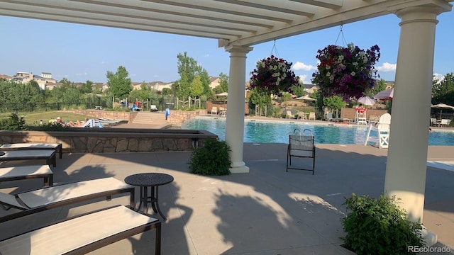 view of patio / terrace featuring a community pool and fence