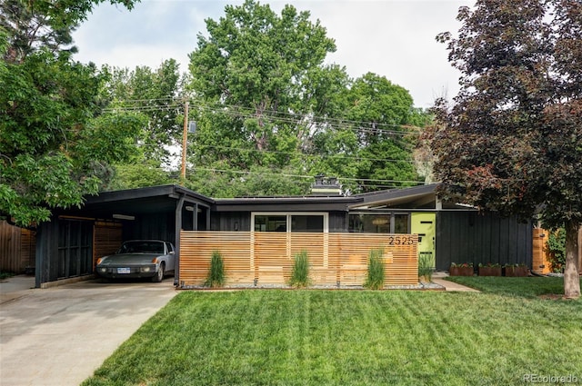 2525 S Meade St, Denver, CO 80219 - mid-century inspired home featuring concrete driveway, an attached carport, and a front lawn