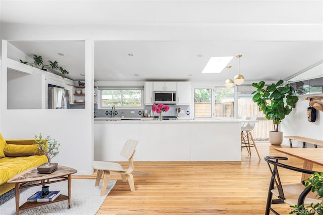 2525 S Meade St, Denver, CO 80219 - dining space with light wood-type flooring and a skylight