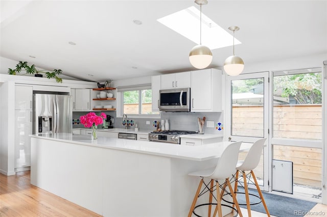 2525 S Meade St, Denver, CO 80219 - kitchen featuring stainless steel appliances, tasteful backsplash, light countertops, hanging light fixtures, and a skylight