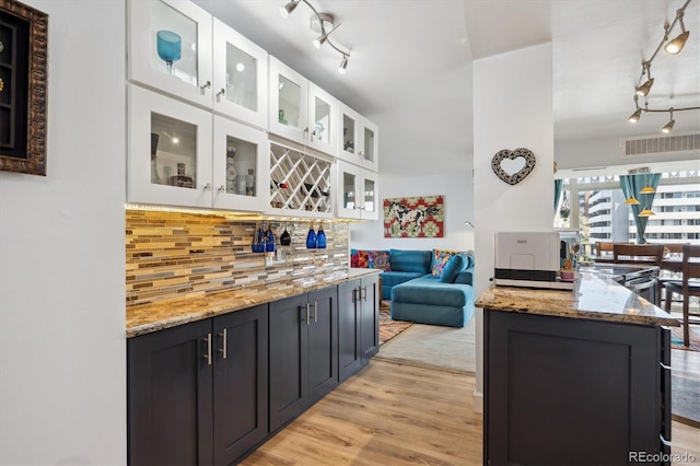1223 Race St Unit 605, Denver, CO 80206 - kitchen with backsplash, visible vents, track lighting, light wood finished floors, and white cabinetry