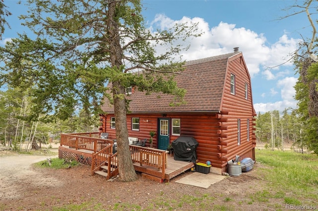 143 Juniper Rd, Black Hawk, CO 80422 - rear view of property featuring a shingled roof, a wooden deck, a gambrel roof, and log exterior