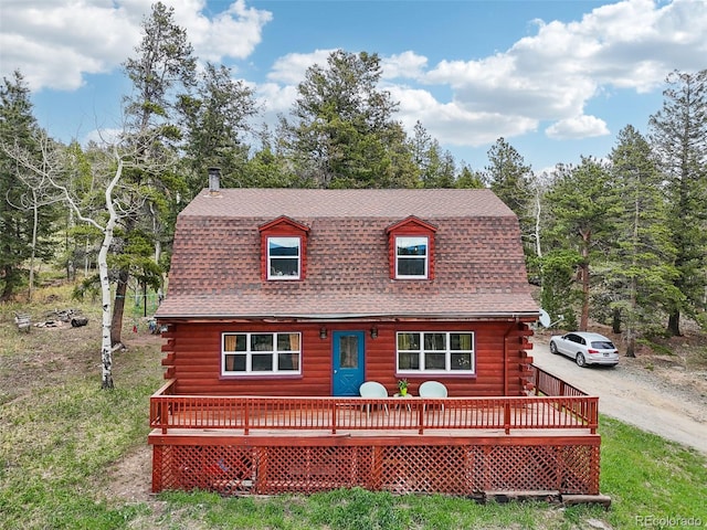 143 Juniper Rd, Black Hawk, CO 80422 - view of front of house with log exterior, a deck, roof with shingles, and driveway