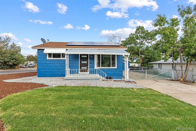 bungalow-style home featuring a front yard and solar panels