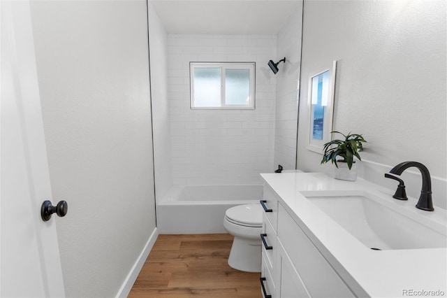 full bathroom featuring hardwood / wood-style flooring, vanity, tiled shower / bath combo, and toilet