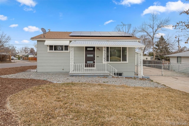 bungalow-style house with a front lawn and solar panels