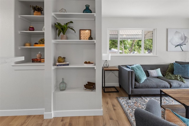 living room featuring built in features and light wood-type flooring