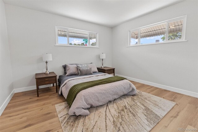 bedroom featuring multiple windows and light hardwood / wood-style floors