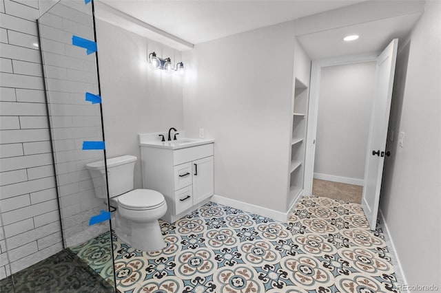 bathroom featuring tile patterned flooring, vanity, a shower, and toilet