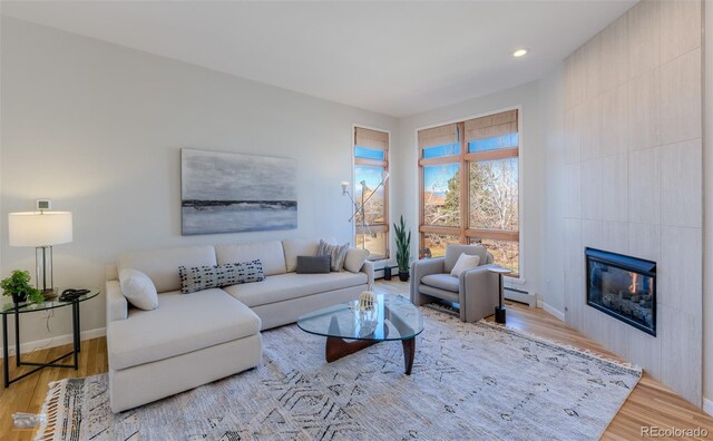 2425 Waneka Lake Trl, Lafayette, CO 80026 - living room with a baseboard radiator, wood finished floors, a tiled fireplace, baseboards, and recessed lighting
