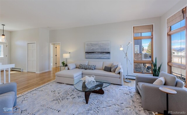 2425 Waneka Lake Trl, Lafayette, CO 80026 - living room featuring a baseboard heating unit, light wood finished floors, and baseboards