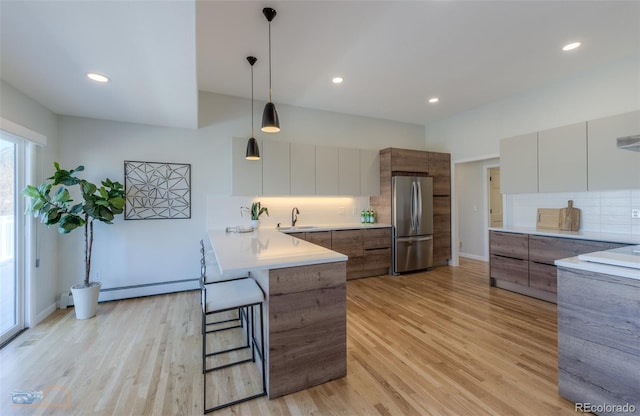 2425 Waneka Lake Trl, Lafayette, CO 80026 - kitchen with freestanding refrigerator, modern cabinets, a baseboard heating unit, a peninsula, and recessed lighting