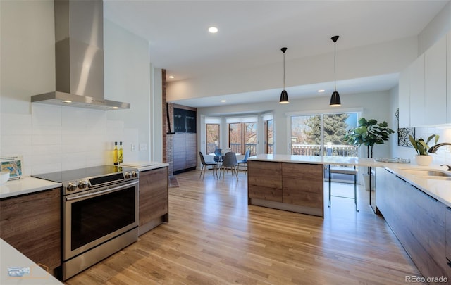 2425 Waneka Lake Trl, Lafayette, CO 80026 - kitchen featuring wall chimney exhaust hood, electric stove, modern cabinets, a sink, and light countertops