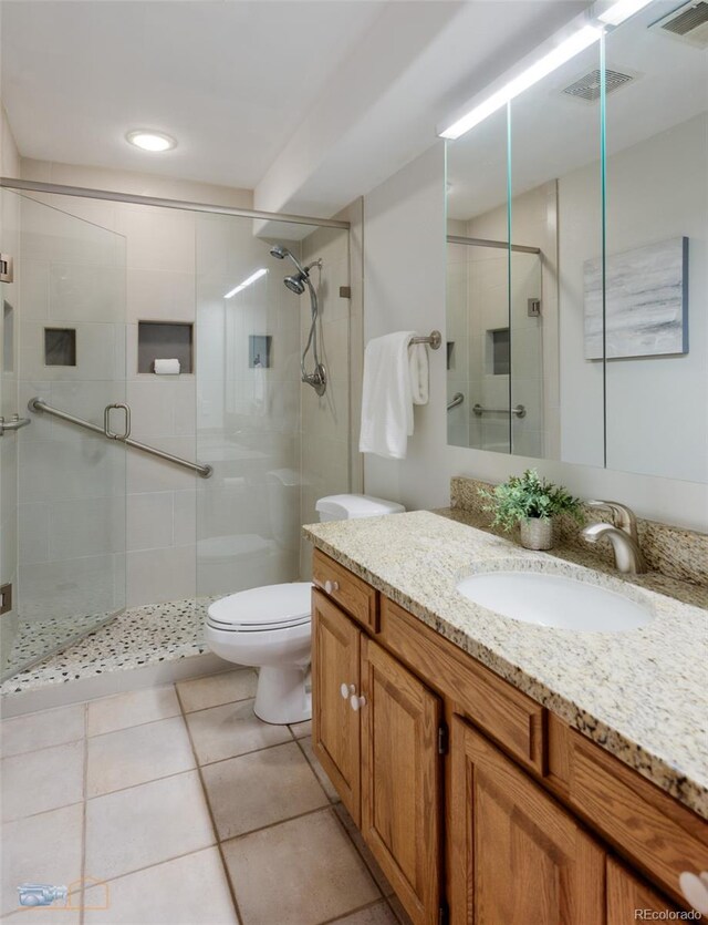2425 Waneka Lake Trl, Lafayette, CO 80026 - bathroom featuring vanity, toilet, a stall shower, and tile patterned floors