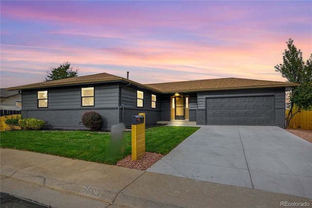 single story home featuring a garage and a yard