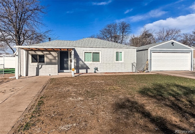 view of front facade featuring concrete driveway, a garage, an outdoor structure, and a front lawn