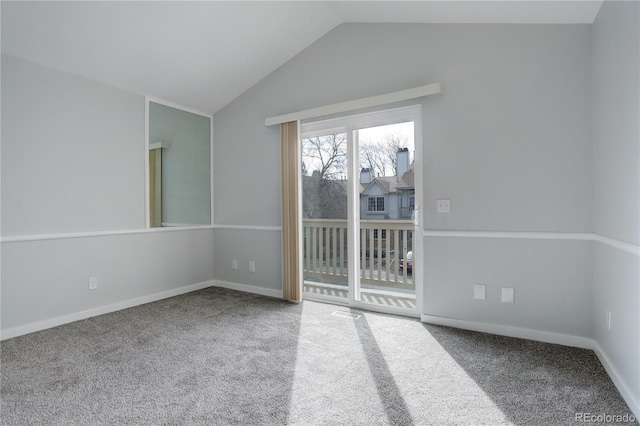 carpeted spare room with vaulted ceiling