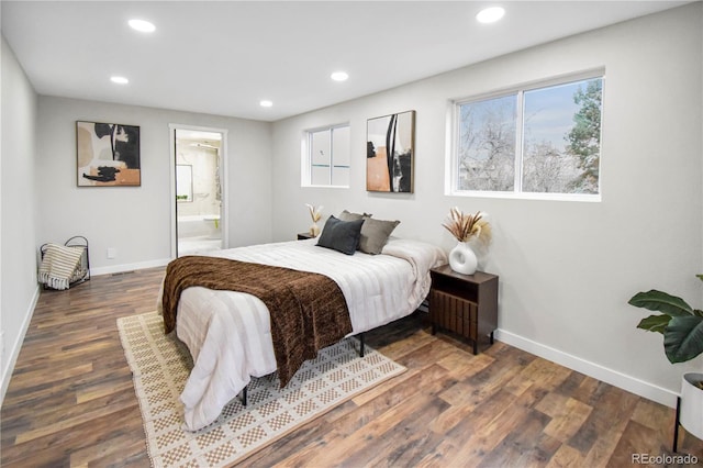 bedroom with ensuite bathroom and dark hardwood / wood-style floors